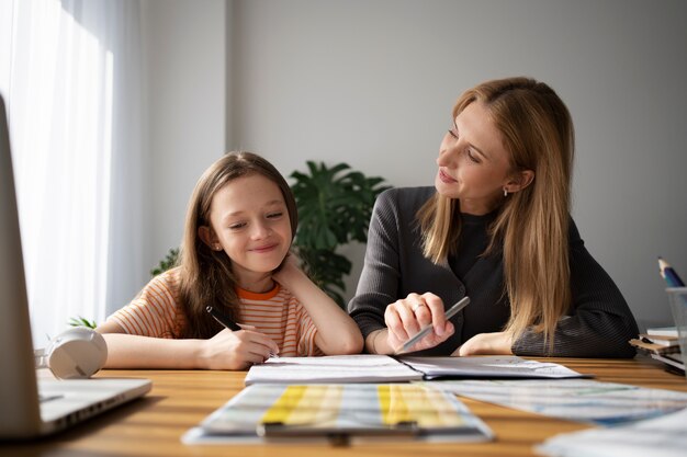 Profesor ayudando a niña a aprender inglés