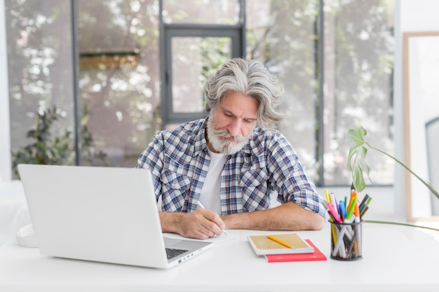 Profesor en el escritorio escribiendo en el cuaderno