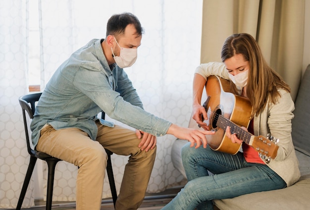 Foto gratuita profesor de guitarra que muestra a la mujer cómo jugar