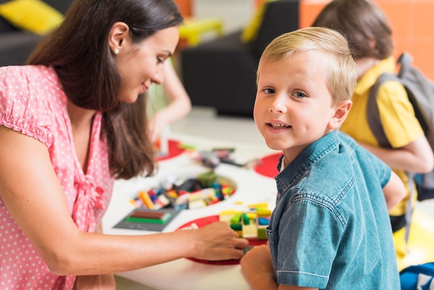 Foto gratuita profesor jugando con niños de jardín de infantes