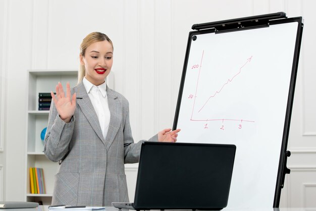 Profesor lindo instructor en traje en clase con computadora y pizarra diciendo adiós