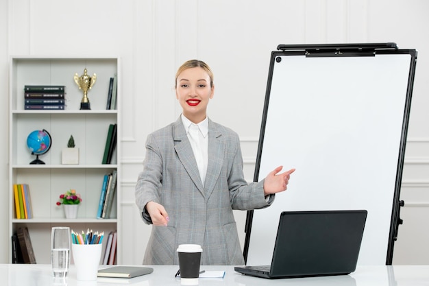 Profesor lindo instructor en traje en clase con computadora y pizarra sonriendo con taza de café