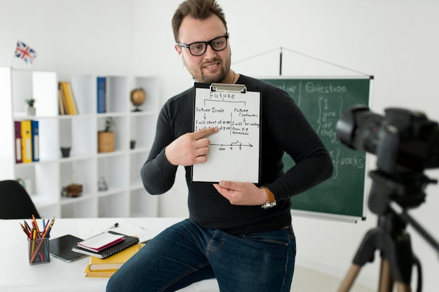 Profesor masculino haciendo una lección de inglés en línea para sus alumnos