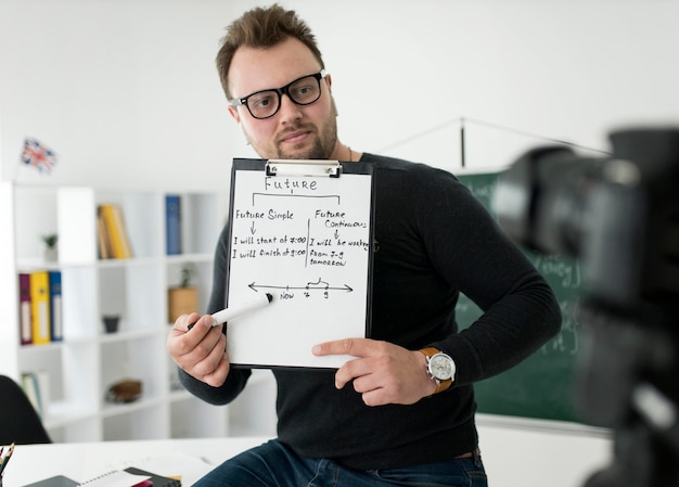 Profesor masculino haciendo una lección de inglés en línea para sus alumnos