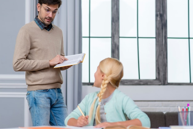 Foto gratuita profesor de pie y niño escuchándolo