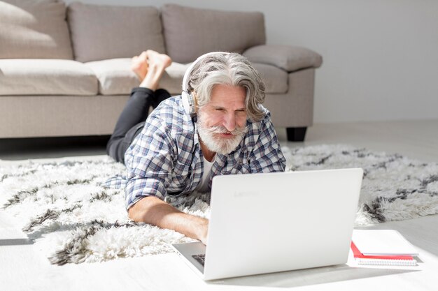 Profesor en piso usando laptop