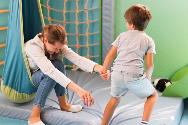 Profesor riendo de la mano del niño