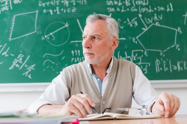 Profesor serio mirando a otro lado en el aula