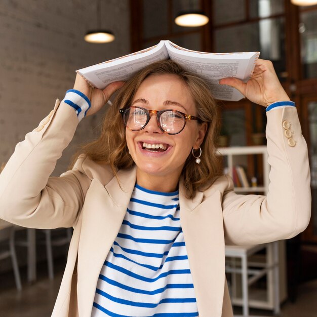 Profesor sonriente retrato con libro en la cabeza.