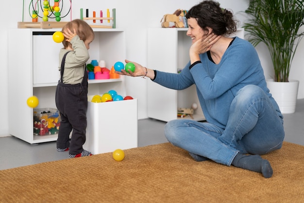 Profesor sonriente de tiro completo jugando con niño