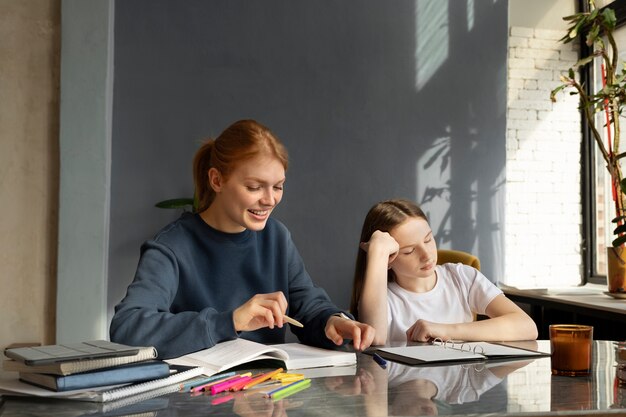 Profesor sonriente de tiro medio y niña cansada