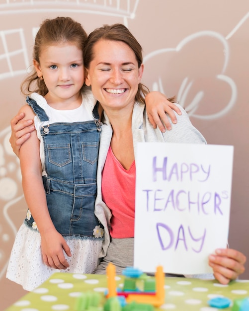 Profesor sonriente de tiro medio con niña