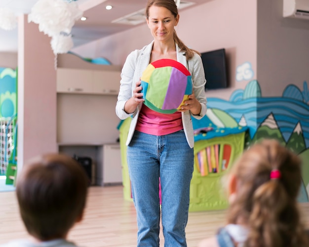 Profesor sosteniendo bola colorida