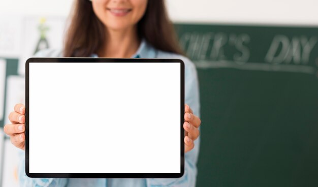Profesor sosteniendo una tableta con pantalla vacía