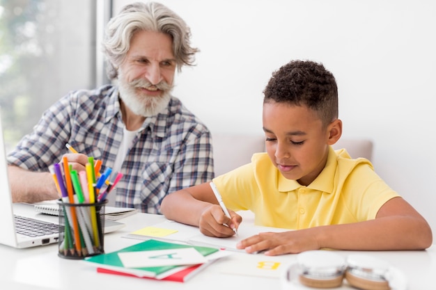 Profesor de tiro medio mirando la escritura del estudiante