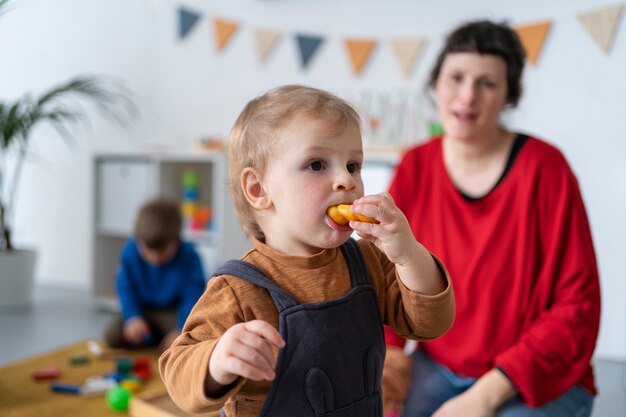 Profesor de tiro medio viendo comer a un niño