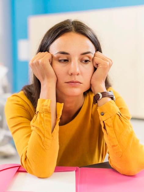 Profesor de vista frontal mirando triste en clase