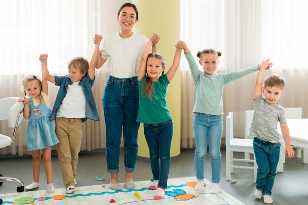 Profesor de vista frontal y niños posando juntos