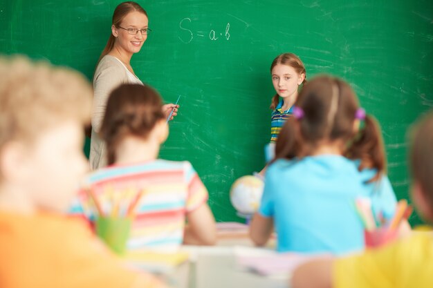 Profesora explicando aritmética en la pizarra