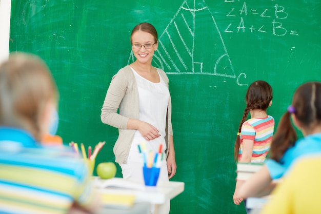 Foto gratuita profesora explicando en la pizarra