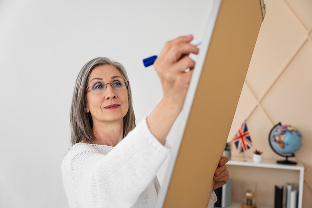 Profesora de inglés sonriente haciendo lecciones en línea