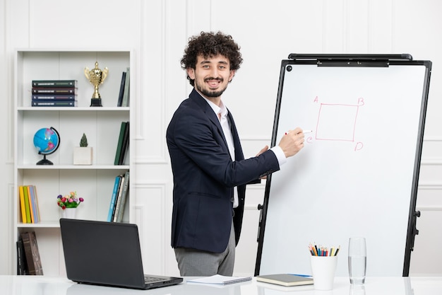 Profesora instructora morena con computadora en traje y pizarra en el aula explicando la conferencia