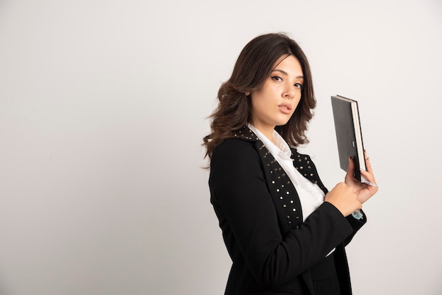 Profesora posando con libro en blanco.