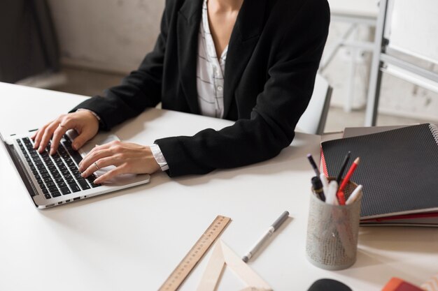 Profesora de primer plano preparando la lección en la computadora portátil