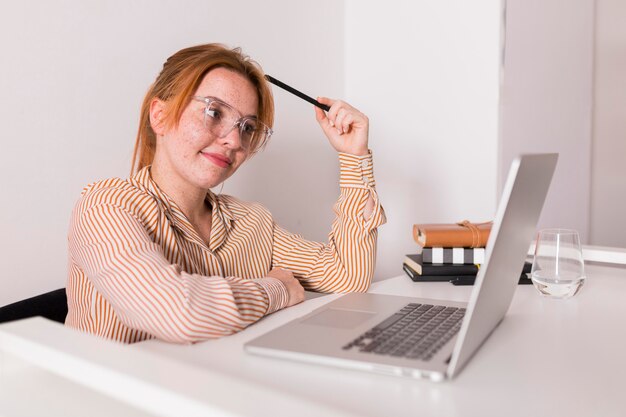 Profesora sonriente usando laptop durante la clase en línea