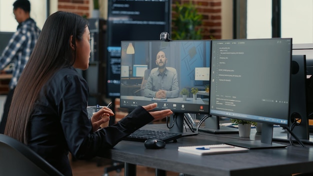 Foto gratuita programador de software independiente en videoconferencia con el propietario del proyecto discutiendo la fecha límite de codificación en la oficina con el trabajo en equipo. programador conversando en línea con el supervisor sobre el código fuente.