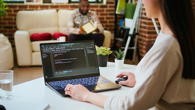 Programadora asiática trabaja en la codificación de software en una configuración de oficina en casa