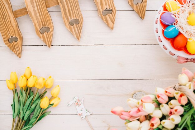 Prop Pascua; tulipanes huevos de Pascua; tulipanes y valla en escritorio de madera