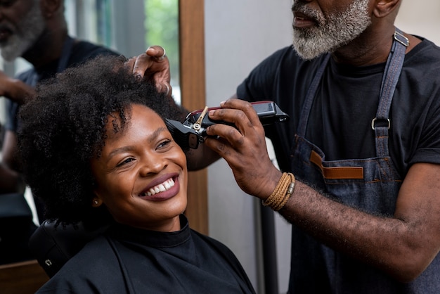 Foto gratuita propietario de peluquería latina cuidando a un cliente