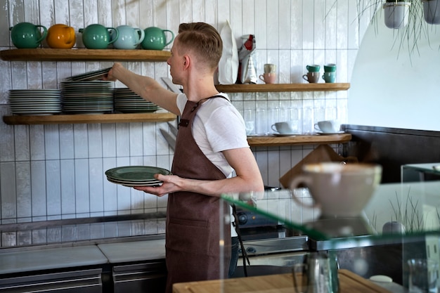 Propietario de una pequeña empresa limpiando una cafetería