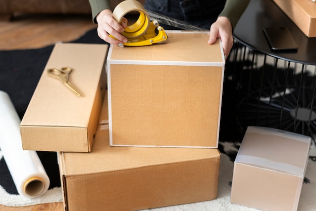 Propietario de una pequeña empresa que embala las cajas del paquete del producto para la entrega