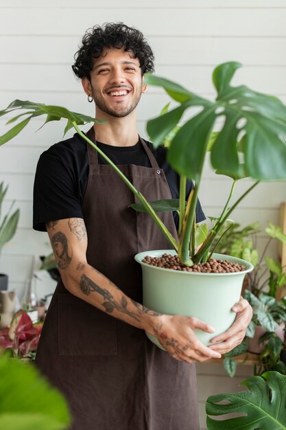 Propietario de una pequeña empresa sosteniendo una planta en maceta en la tienda