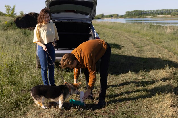 Propietarios de tiro completo dando agua para perros