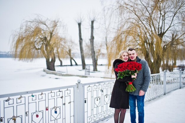 Propuesta de matrimonio con 101 rosa en día de invierno Pareja amorosa