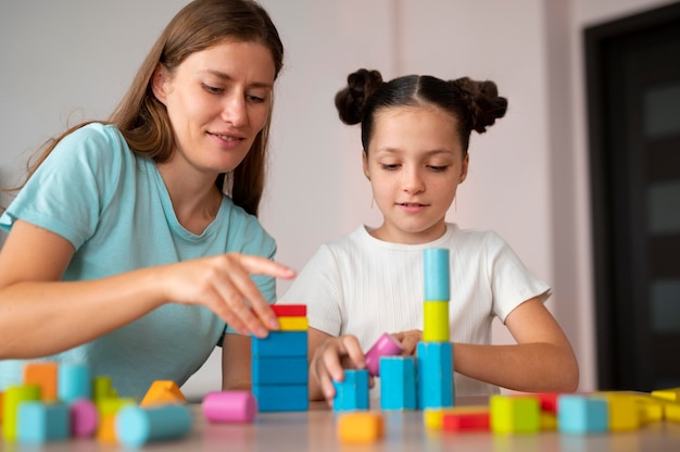 Psicóloga joven ayudando a una niña en logopedia