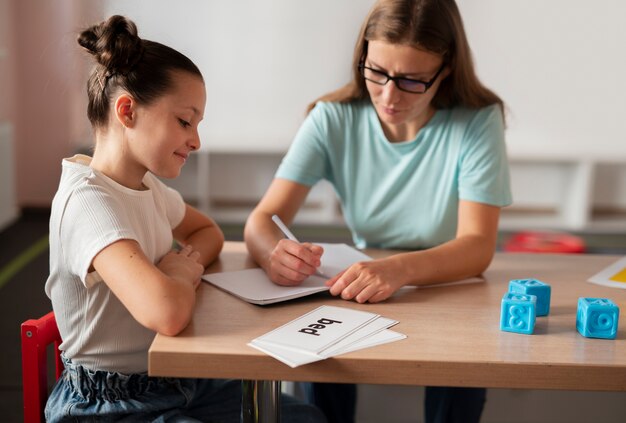 Psicóloga joven ayudando a una niña en logopedia