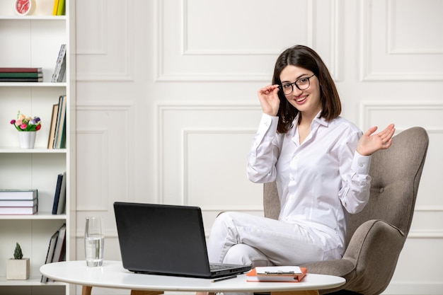 Psicóloga morena linda joven profesional brindando sesiones en línea con gafas puestas