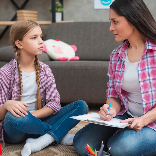 Foto gratuita psicóloga teniendo sesión con su paciente niña en oficina