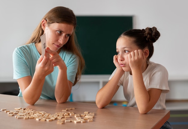 Psicólogo ayudando a una niña en logopedia