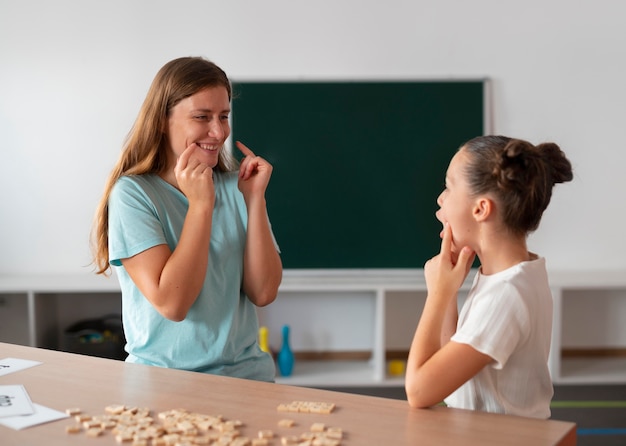 Psicólogo ayudando a una niña en logopedia