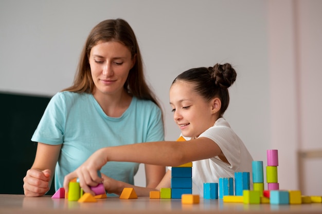 Foto gratuita psicólogo ayudando a una niña en logopedia