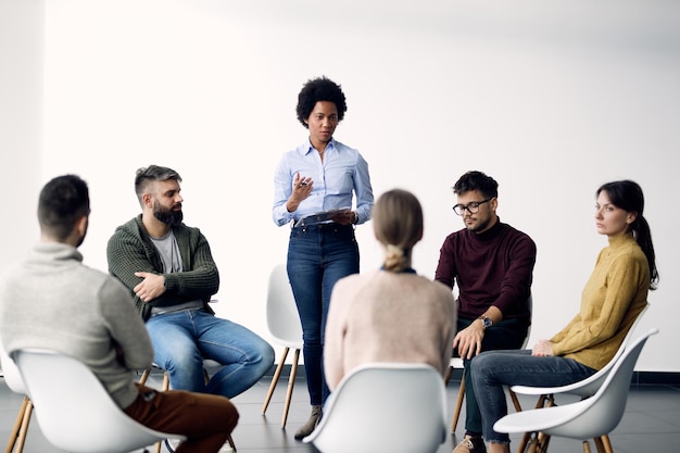 Foto gratuita psicoterapeuta afroamericano dirigiendo una reunión de grupo en el centro comunitario