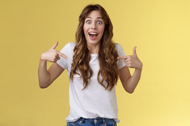 Puedes creer, fascinante. Impresionada sociable linda chica diciéndole a un amigo excelente cerca de ser elegida consiguió trabajo señalando con el dedo índice ella misma centro copia espacio camiseta blanca mirada sorprendida sonriendo.