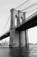 Foto gratuita puente de brooklyn en blanco y negro sobre el east river visto desde el paseo marítimo del bajo manhattan de la ciudad de nueva york.