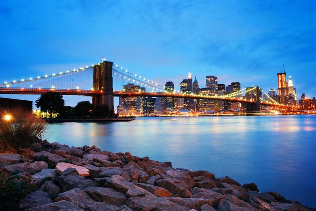 El puente de Brooklyn y el horizonte de Manhattan en la ciudad de Nueva York sobre el río Hudson por la noche.