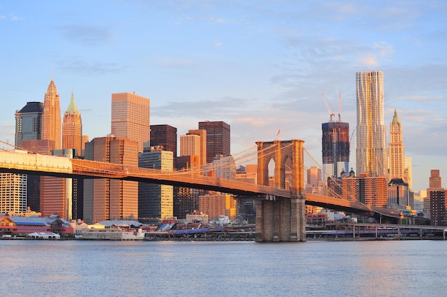 Foto gratuita puente de brooklyn con el horizonte de manhattan más bajo por la mañana con nubes coloridas sobre east river en la ciudad de nueva york